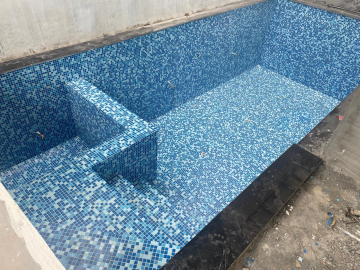 A standard rectangular home pool with a slide and a diving board.