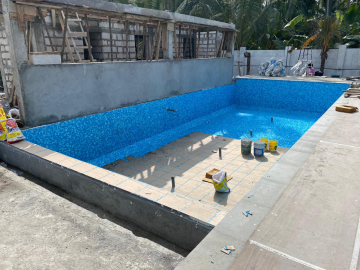 A pool mid-construction being replastered by professional contractors.