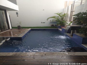 A peaceful backyard pond with lily pads and decorative surrounding rocks.
