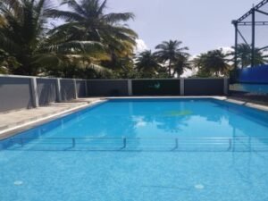 A luxury pool with an overflow drainage system along the deck edge.