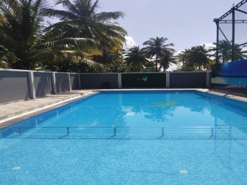 A luxury pool with an overflow drainage system along the deck edge.