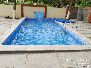 A standard rectangular home pool with a slide and a diving board.