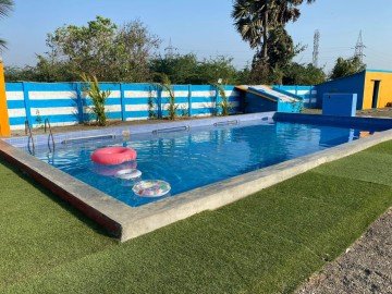 An instructor teaching a group of children how to kick in a dedicated swim academy lane.
